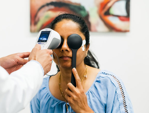 Woman undergoing ERG test using RETeval handheld device